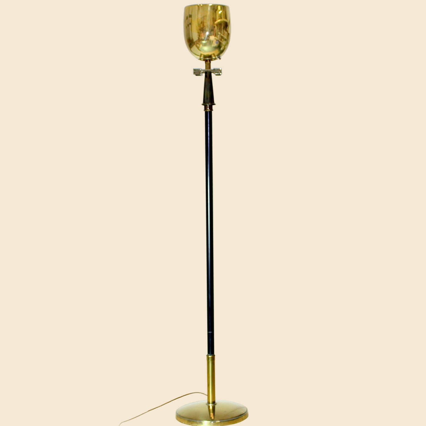 Vintage-style floor lamp with gold glass shade on a beige background