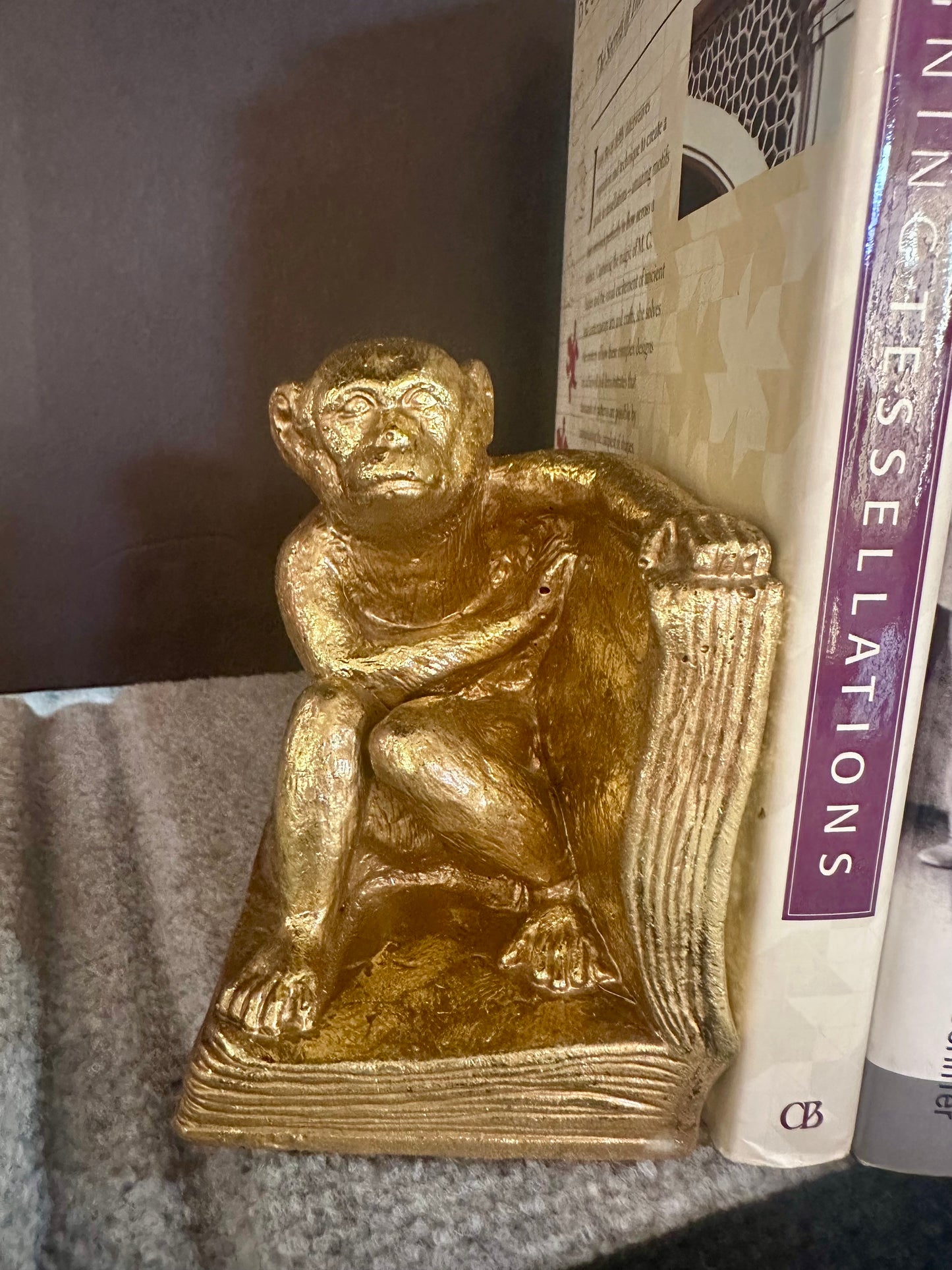 Gold monkey figurine on a stack of books with a blurred background