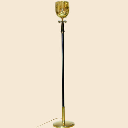 Vintage-style floor lamp with gold glass shade on a beige background
