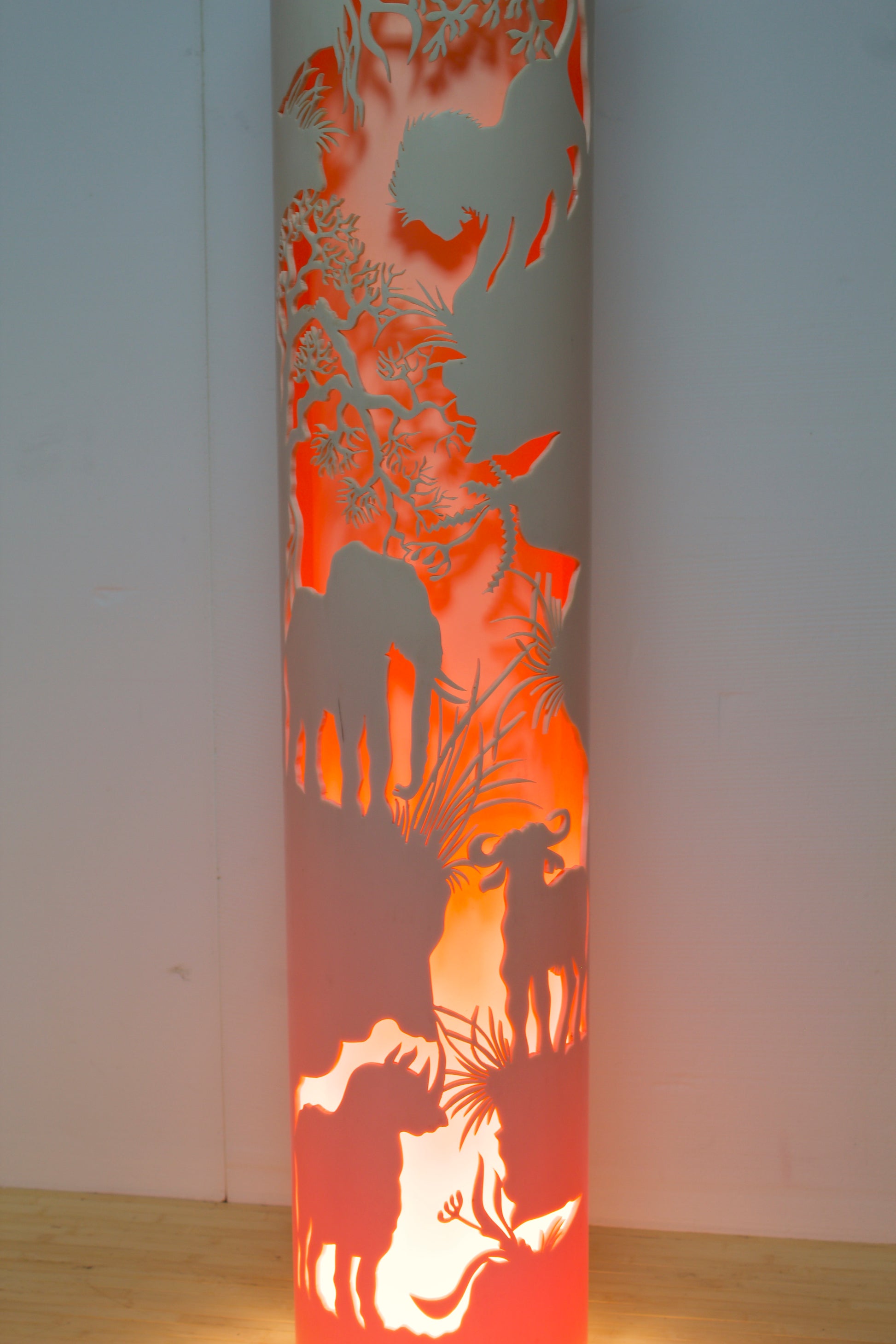 Close up of a floor lamp with a jungle scene cut into the shade