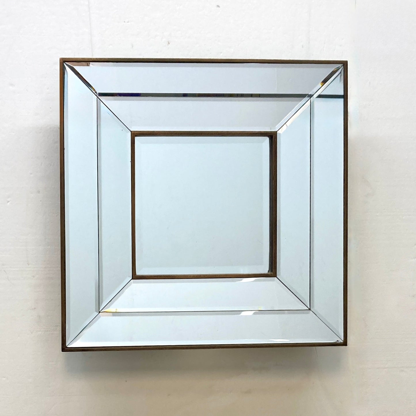Geometric mirror with a copper-toned frame.