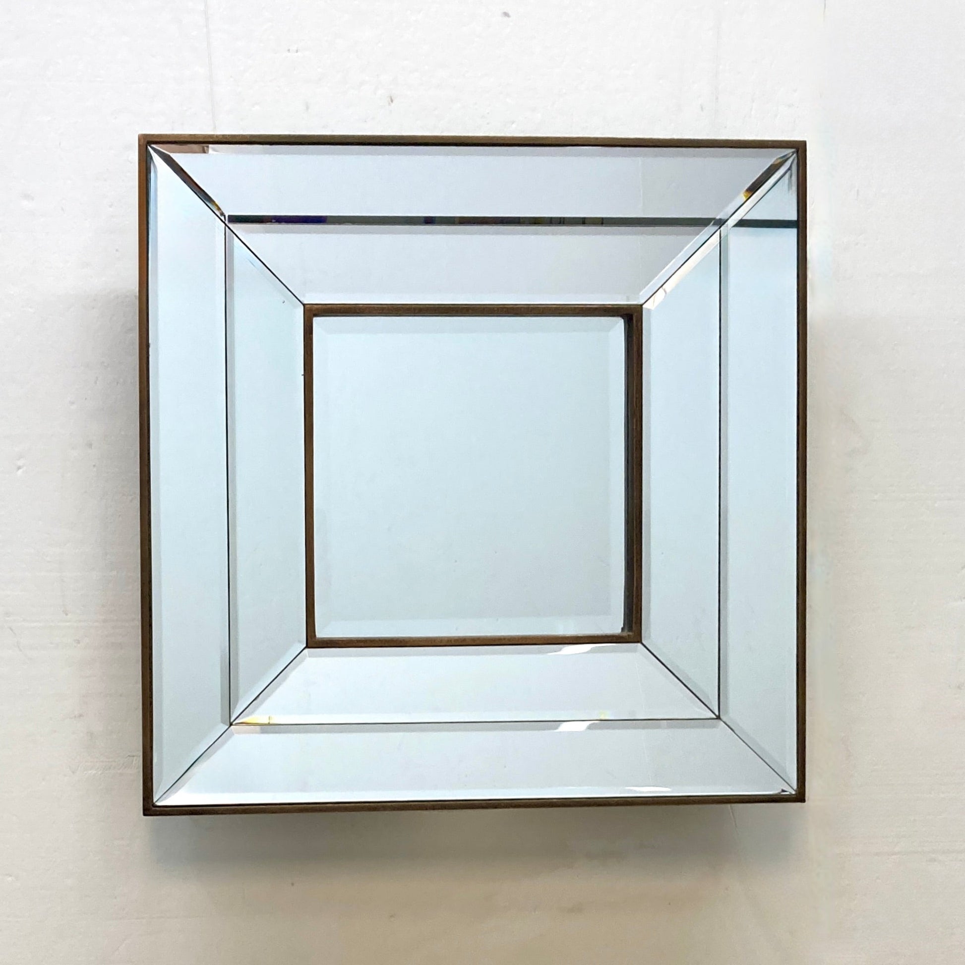 Geometric mirror with a copper-toned frame.