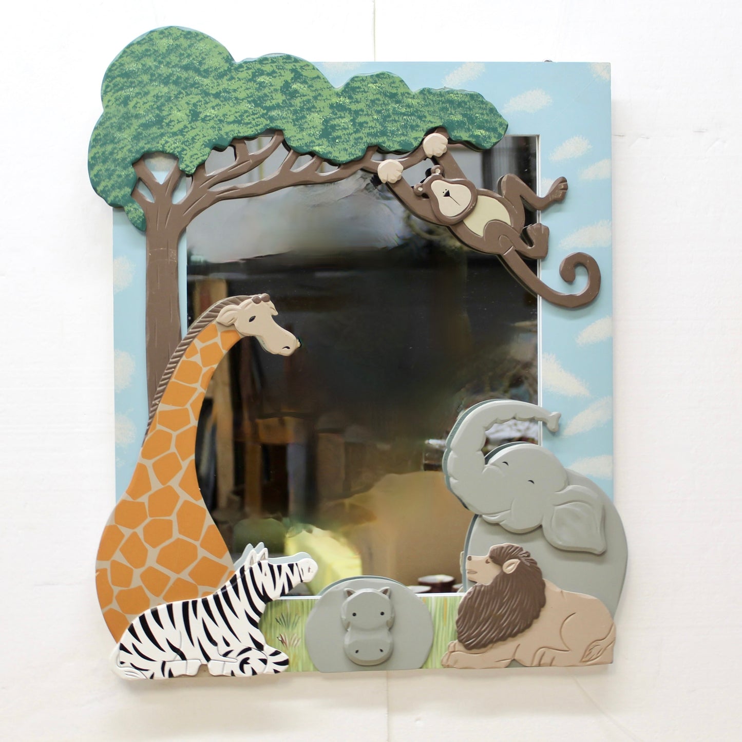 Decorative mirror with animal-themed frame including a giraffe, monkey, elephant, zebra, and lion.