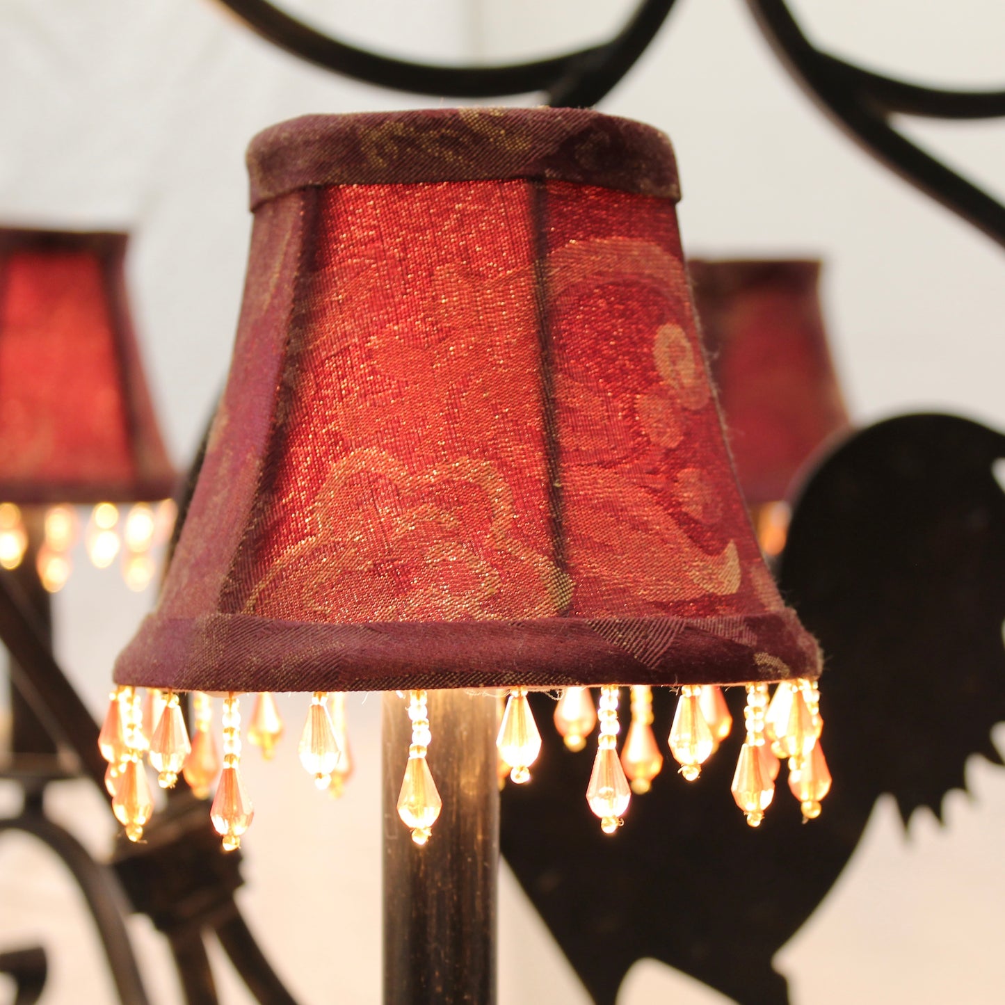 Decorative lamp with a red lampshade and visible bulbs against a blurred background