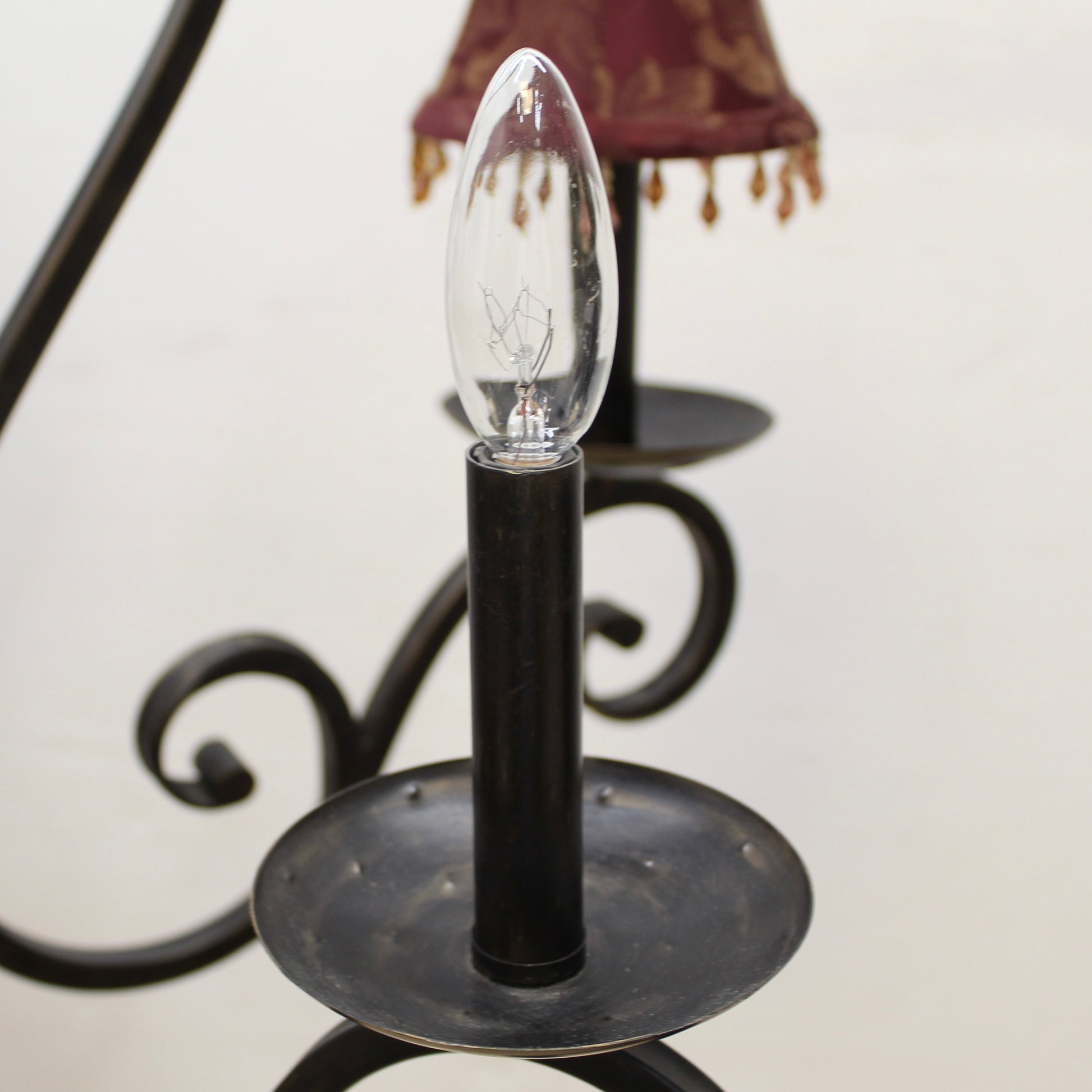 Light bulb on a black holder with a blurred lamp in the background