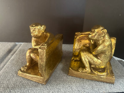 Gold monkey bookends on a textured surface with a dark background