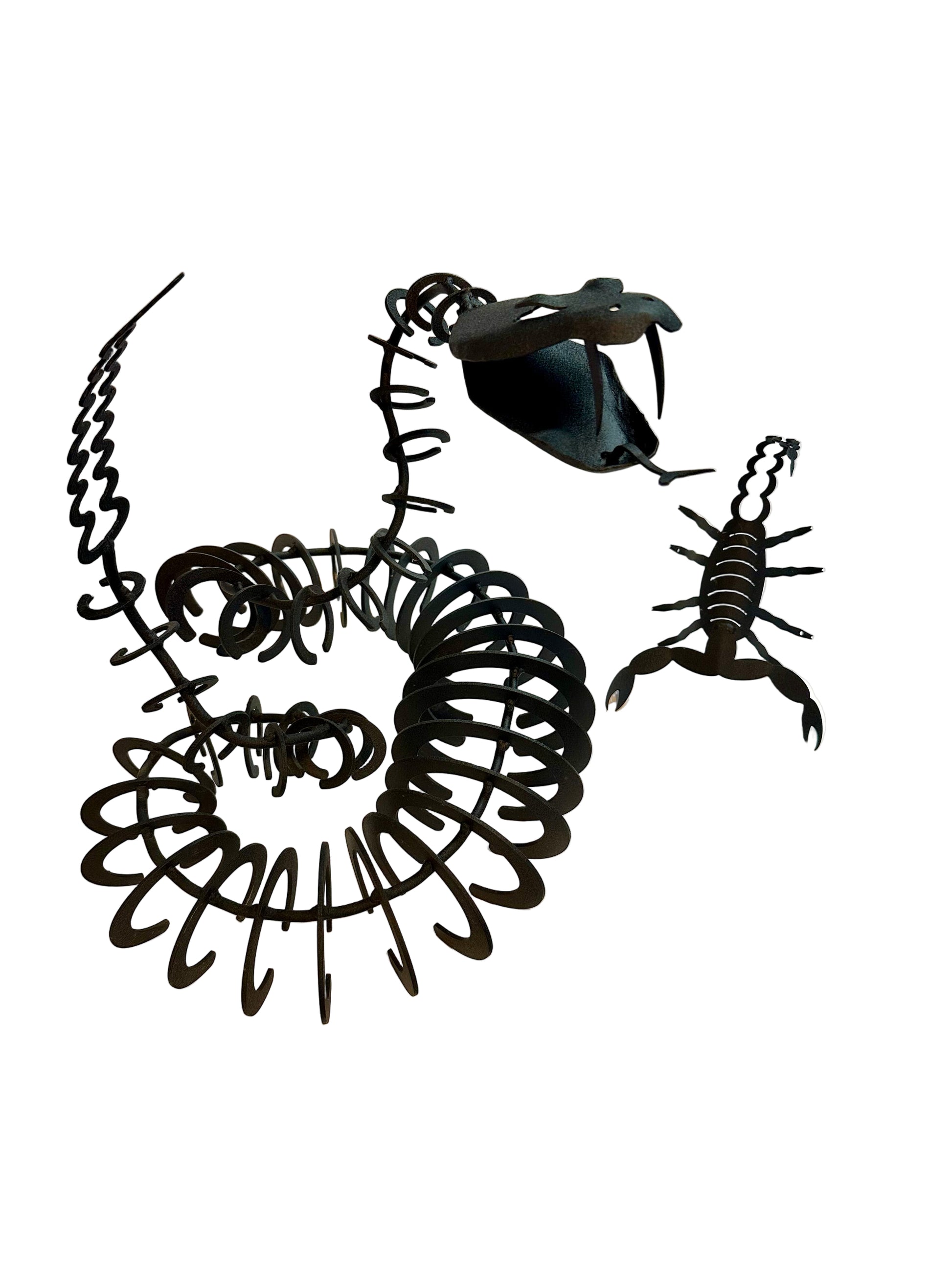Black metal scorpion sculptures on a white surface with a blurred background