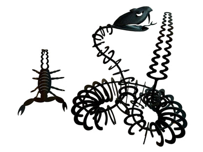 Black iron sculptures of scorpion and snake on a white surface