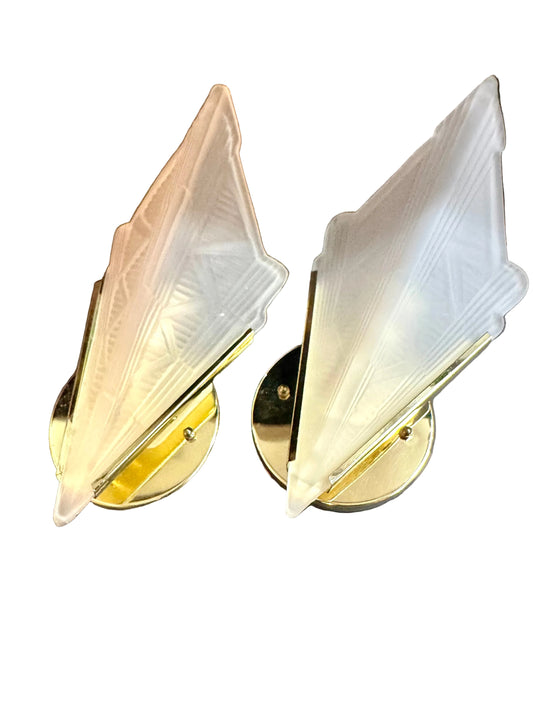 Pair of gold and white wall sconces on a white background