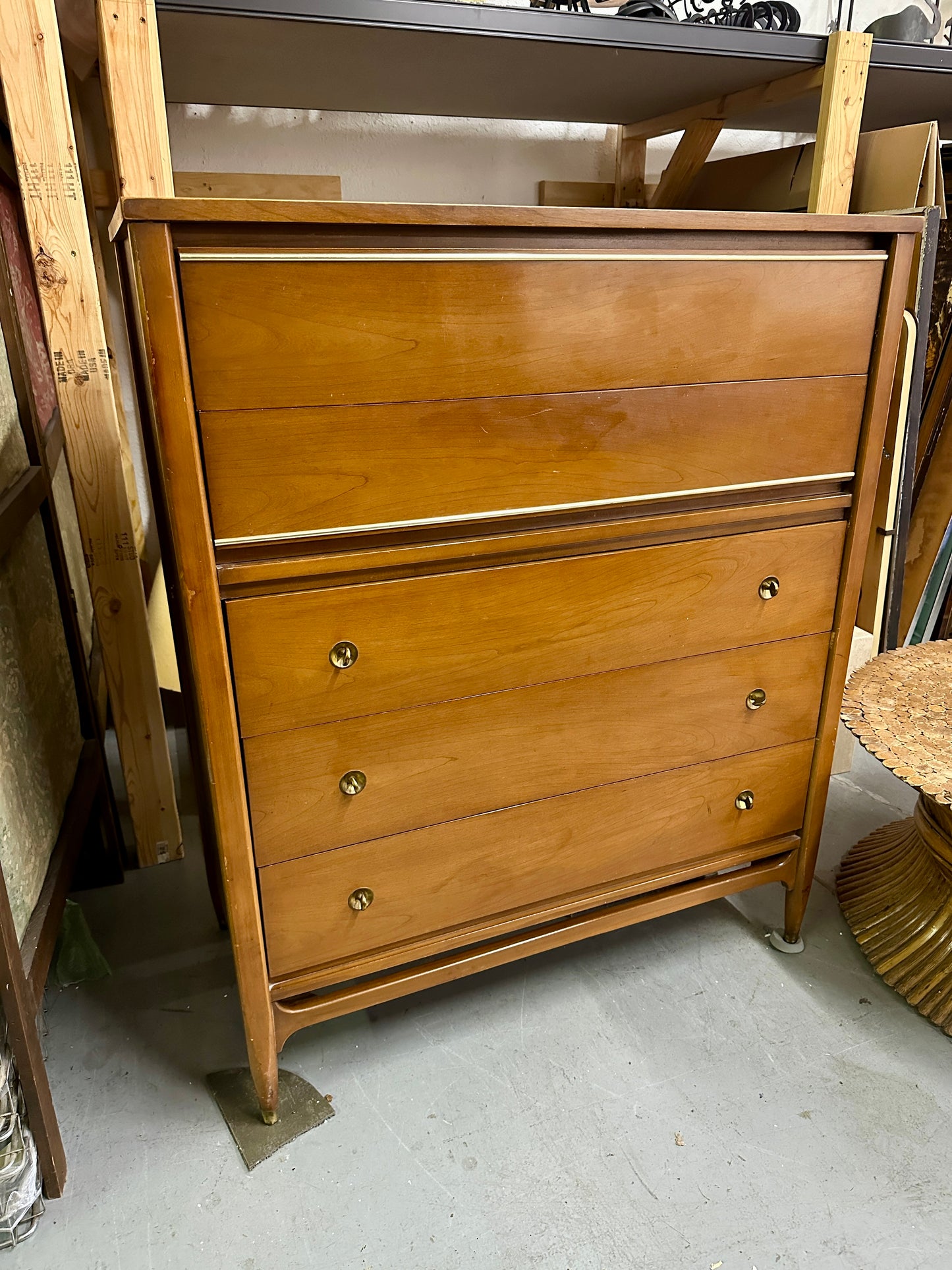 Wooden dresser with four drawers in a storage or warehouse setting