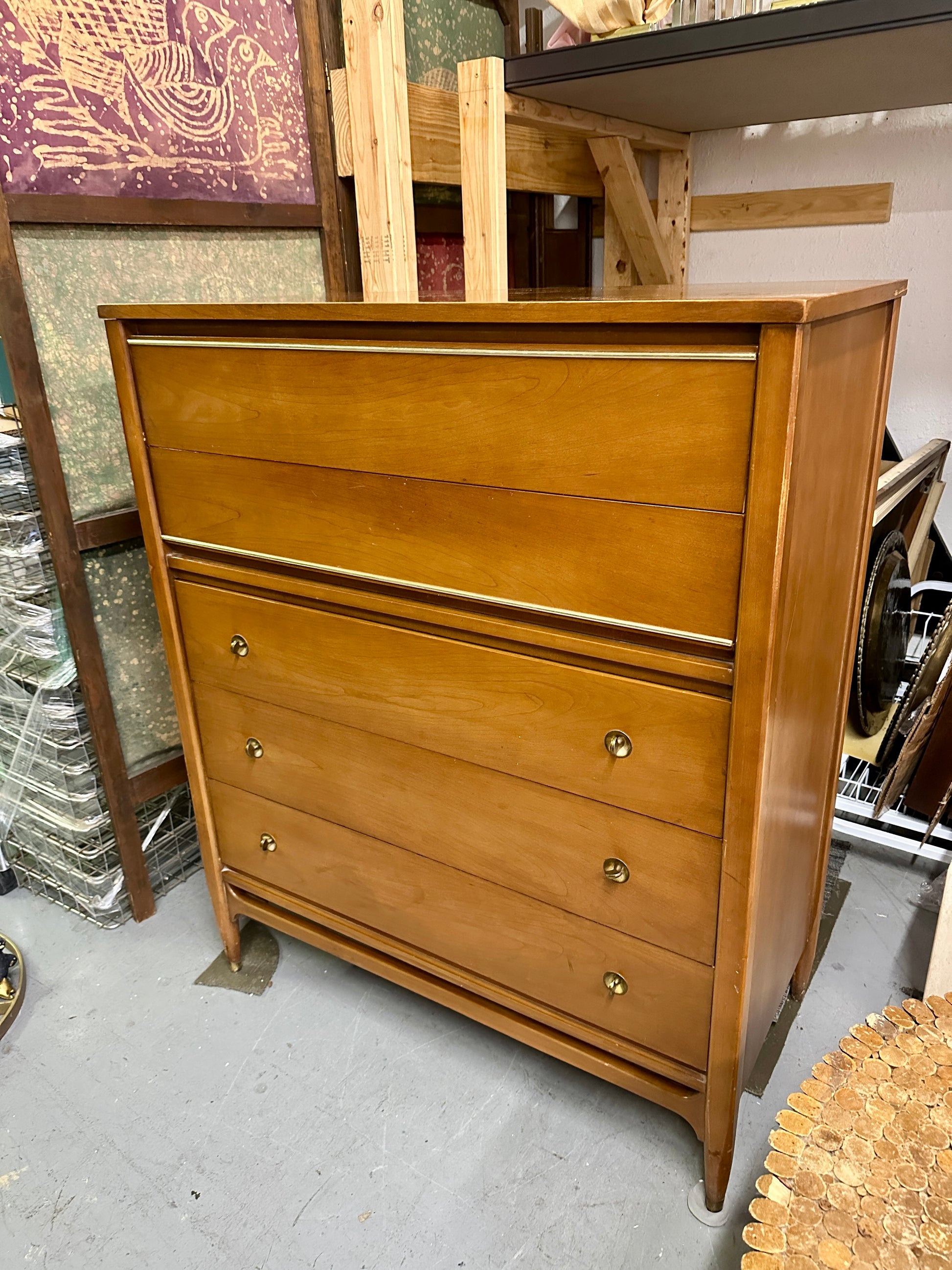 Wooden dresser with four drawers in a storage or warehouse setting