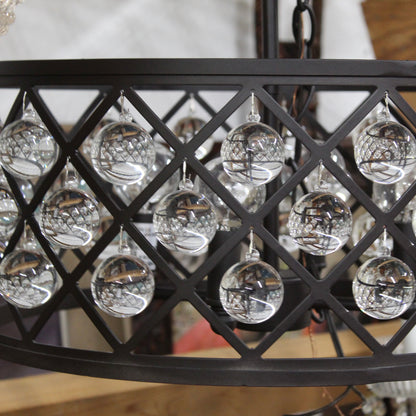 Close-up of a chandelier with crystal balls and black metal frame.