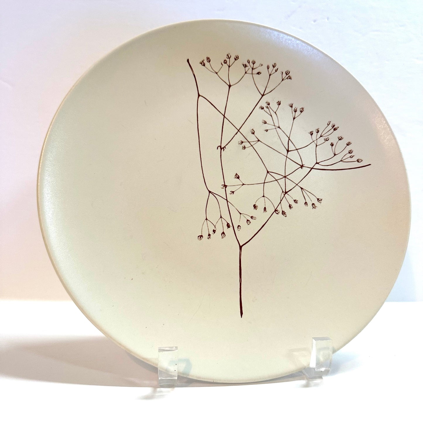 Ceramic plate with a black branch design on a white background