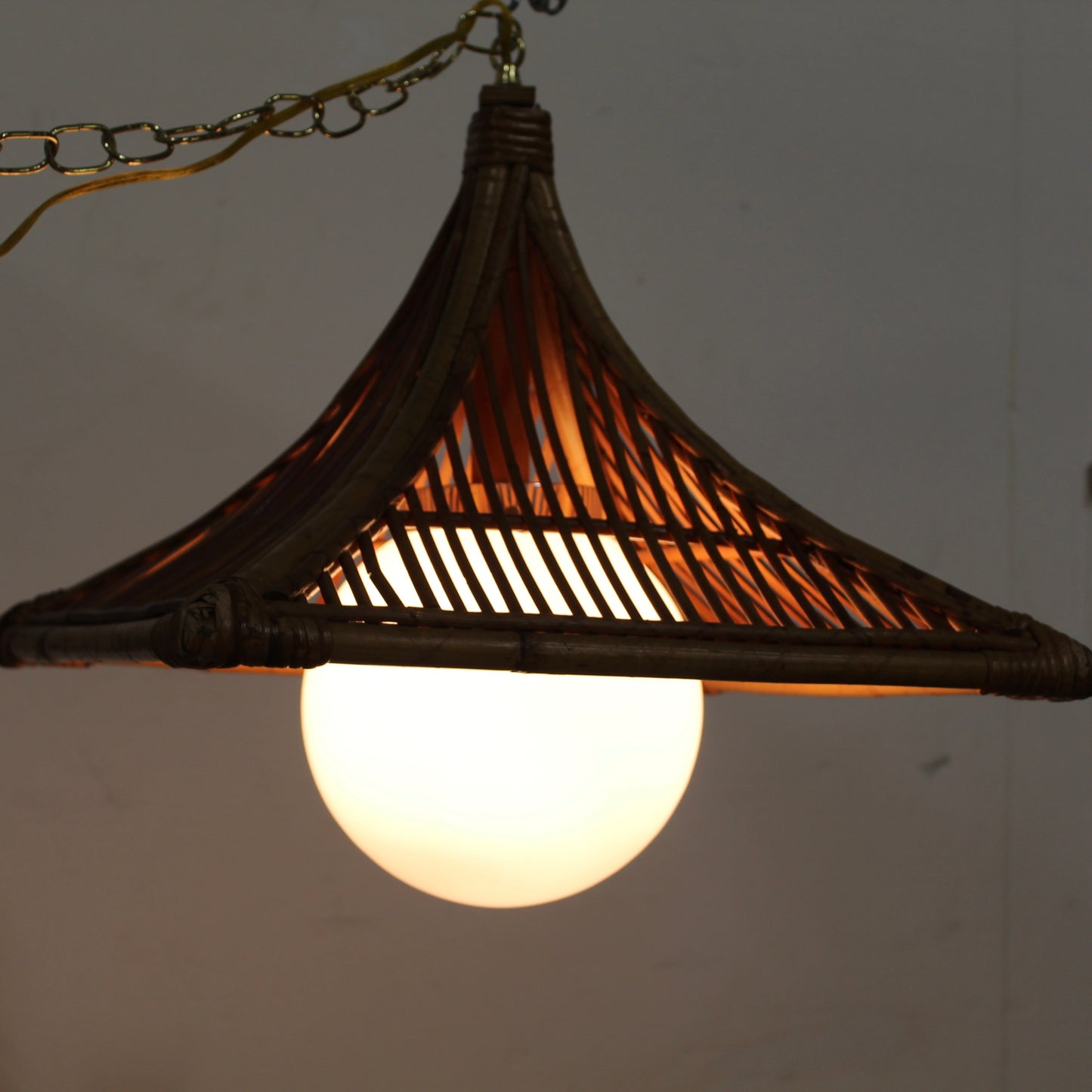 Large square bamboo frame over a white glass orb light. 