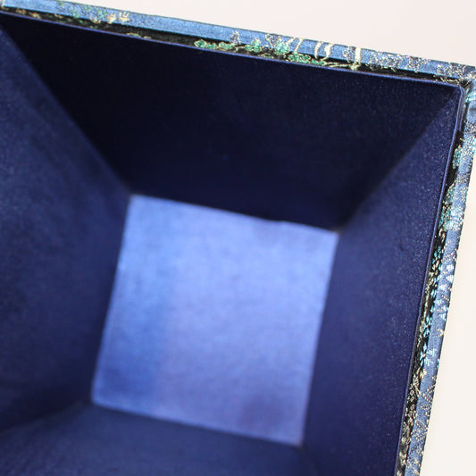 Inside a Navy blue Chinoiserie brocade square planter. 