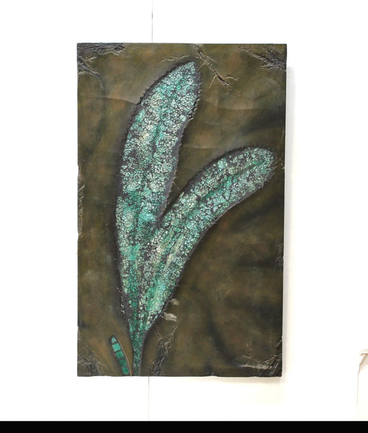 Decorative glass wall art with a large green leaf design on a brown background