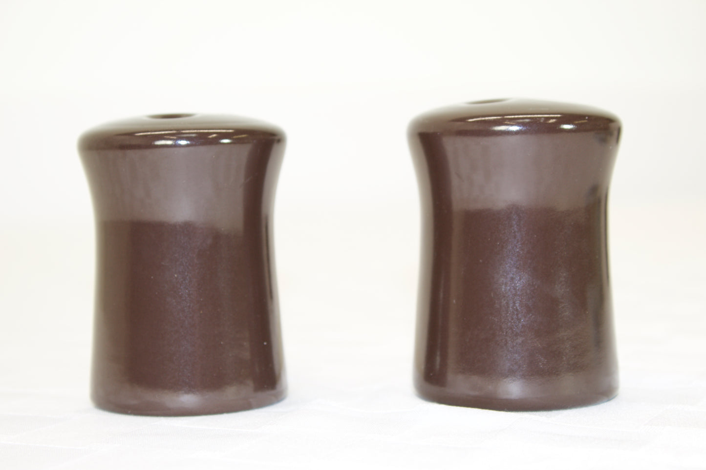 Brown stoneware salt and pepper shakers.