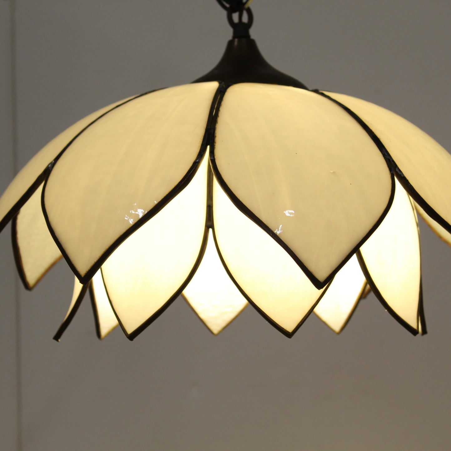 Double-layer tulip or lotus flower motif. The dual tiers of sculpted, milk-white slag glass petals are framed by dark, antiqued metal lead lines.